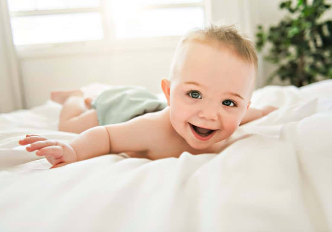 cute-baby-boy-lying-on-a-white-bed-picture-id1213703389
