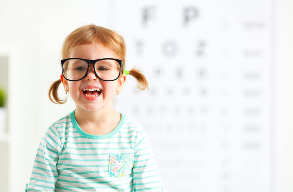 concept vision testing. child  girl with eyeglasses at the doctor ophthalmologist