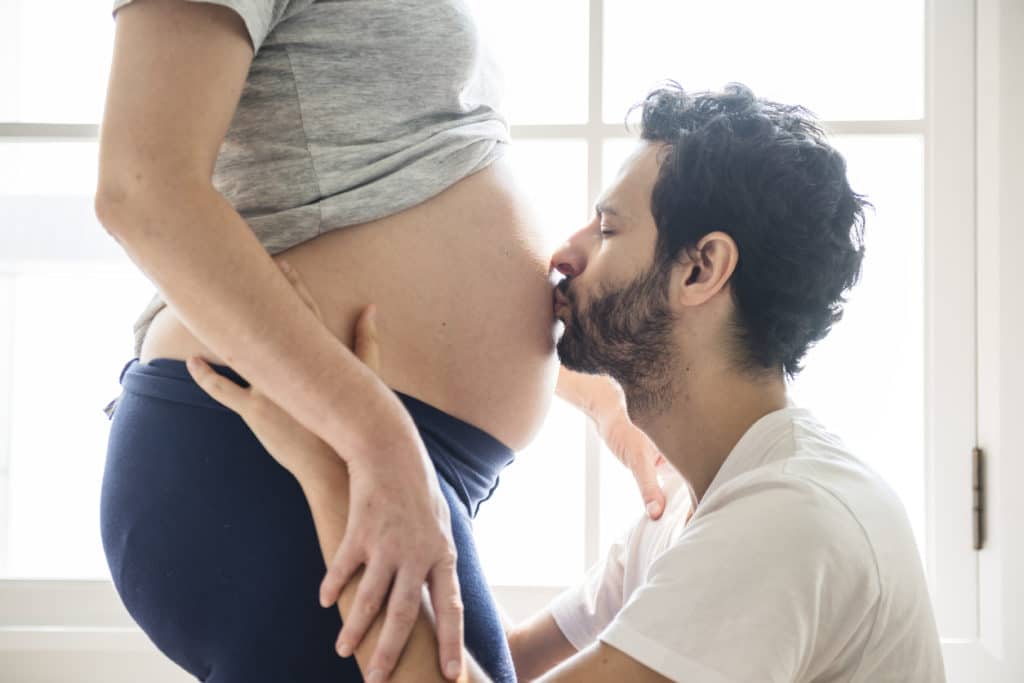 Husband kissing baby bump