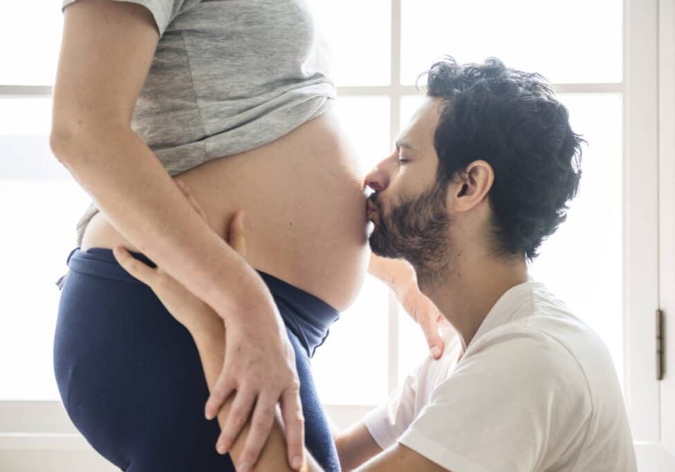 Husband kissing baby bump