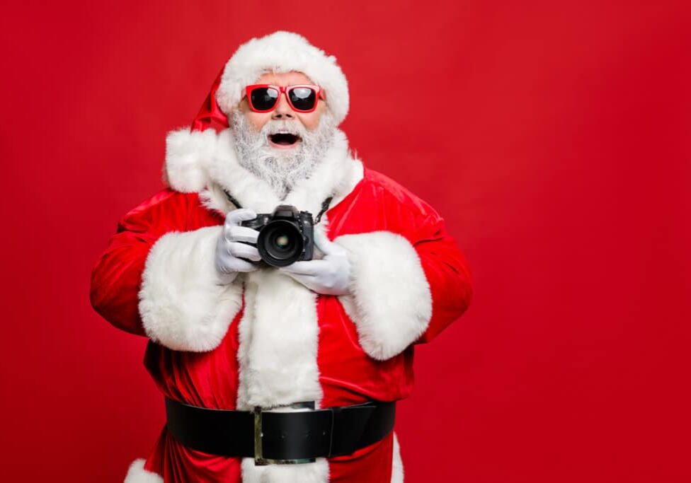 Portrait of excited enthusiastic santa claus in eyewear eyeglasses have voyage take photo, wear stylish costume cap hat belt isolated over red background
